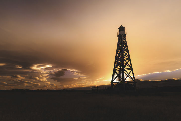 Light The Way - The taller of two abandoned shipping beacons near Hawke's Bay airport, lit from behind by the setting sun