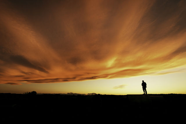 One Hundred Million Angels Singing - A silhouette of a man under an amazing sunset