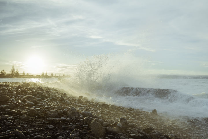 Westshore Wave - A wave crashes over rocks and the spray lit up with late afternoon sunlight