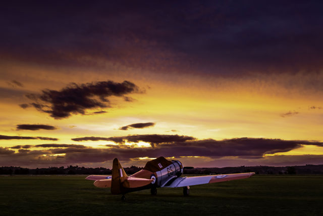 Tomorrow We Fly - Vibrant sunset over a classic Harvard aircraft at Hawke's Bay Airport