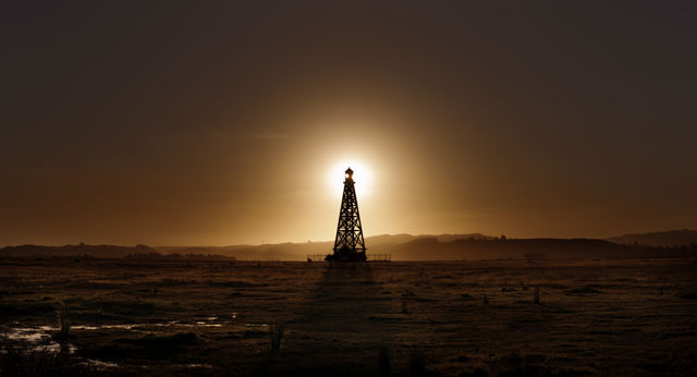 Lit - The taller of two abandoned shipping beacons near Hawke's Bay airport lit from behind by the setting sun
