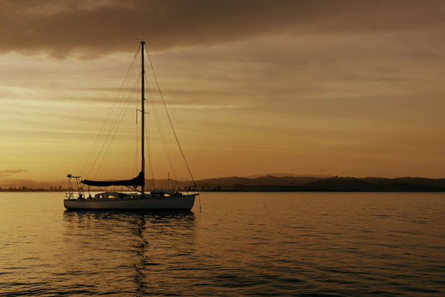 Tea For Two - A yacht anchored near Napier port with the sailors enjoying a sunset dinner.