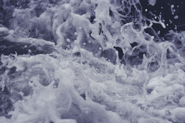 Sea Foam Two - Ocean wave rushing in between rocks creating a beautiful foam.
