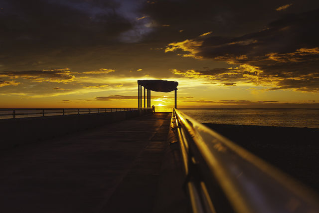 We Fell In Love Down At The Pier 2 - A couple share a moment at sunrise on the viewing platform, Napier, New Zealand.